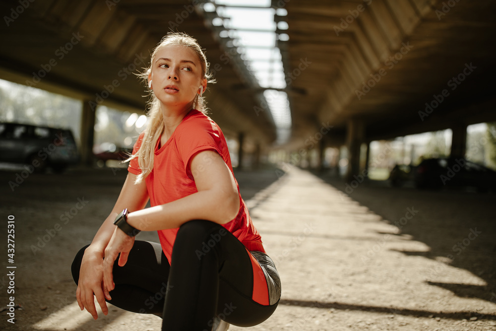 Beautiful young woman resting outdoor after exercises, looking away and listening a music. Beautiful young woman resting outdoor after exercises, looking away and listening a music.