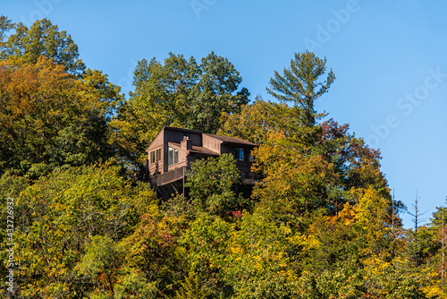 Cliff residential house home lodge building architecture on mountain edge in Basye, Virginia rural countryside town in Shenandoah county in autumn fall with balcony patio terrace