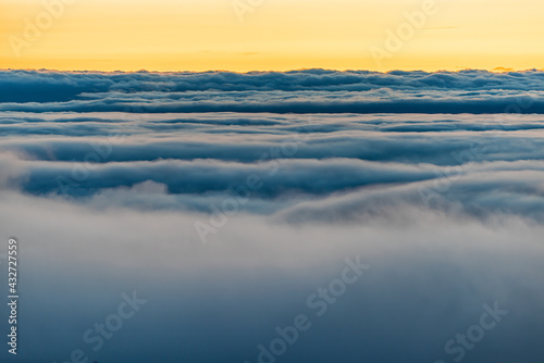 High angle aerial view above inversion clouds cloudscape at sunrise morning in Wintergreen Resort  Virginia ski town with colorful sky above Blue Ridge mountains