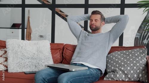 Young man relaxing after work at home while sitting on the couch 