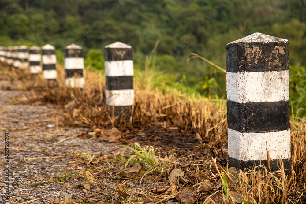 A line of stone bollards on the road over a valley A line of stone bollards on the road over a valley
