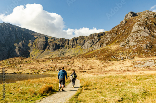 Group of hiking backpackers in Welsh mountains walking next to the lake Llyn Idwal. photo