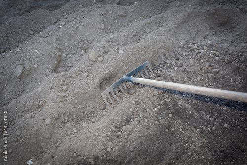 Working with a garden rake after digging the ground.