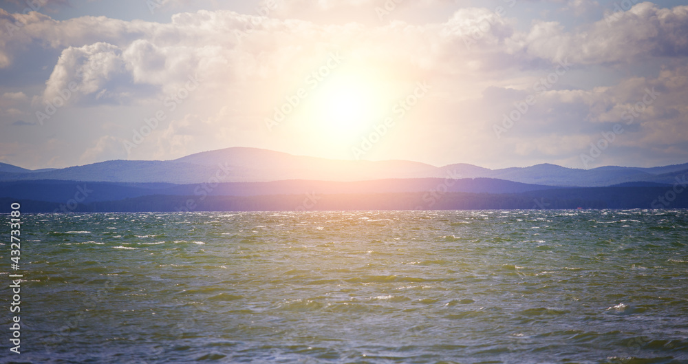 Obraz premium Sunrise over the lake in cloudy sky