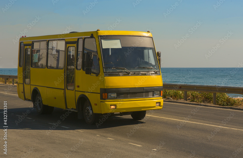 bus moves along the road by the sea
