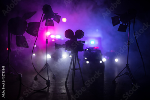 Action movie concept. Police cars and miniature movie set on dark toned background with fog. Police car chasing a car at night. Scene of crime accident.