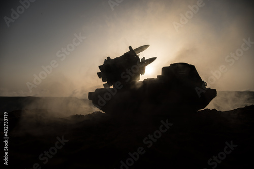 War concept. Battle scene with rocket launcher aimed at gloomy sky at sunset time. Rocket vehicle ready to attacSelective focus