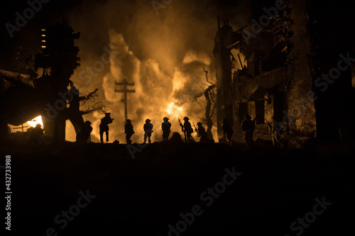 War Concept. Military silhouettes fighting scene on war fog sky background, World War Soldiers Silhouette Below Cloudy Skyline At night. Battle in ruined city. Selective focus