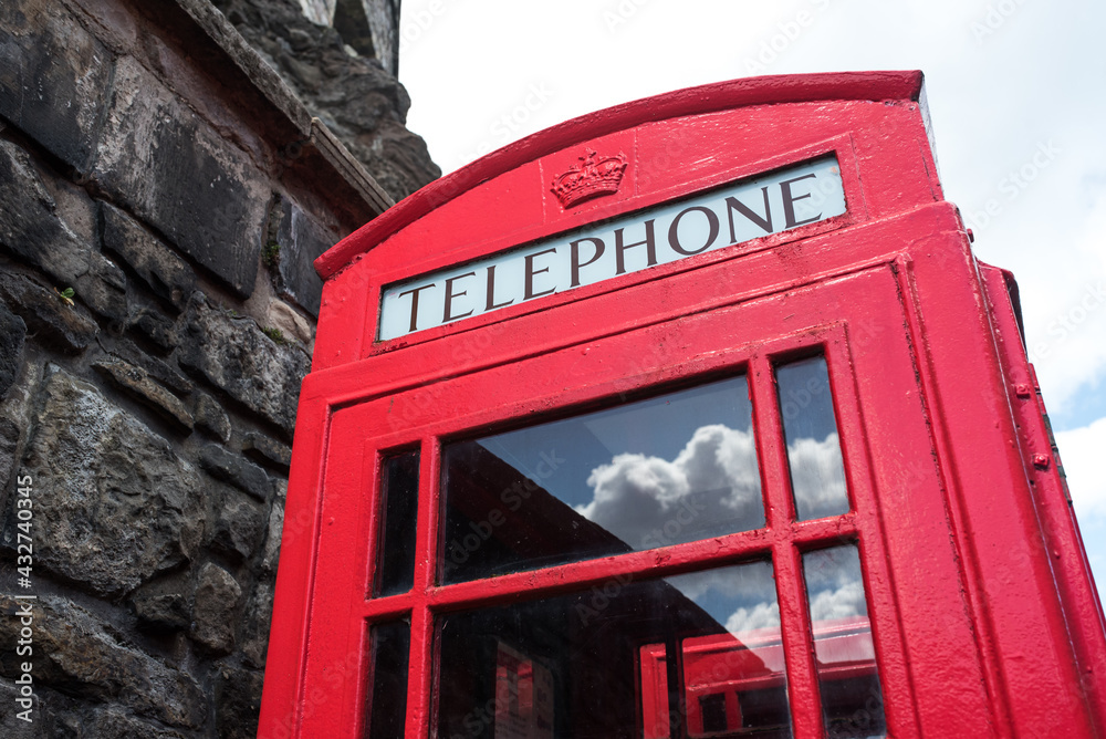 English red telephone booth and clouds reflection on windows. English red telephone booth and clouds reflection on windows.