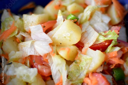 close up view of a potato salad with lettuce and tomatoes