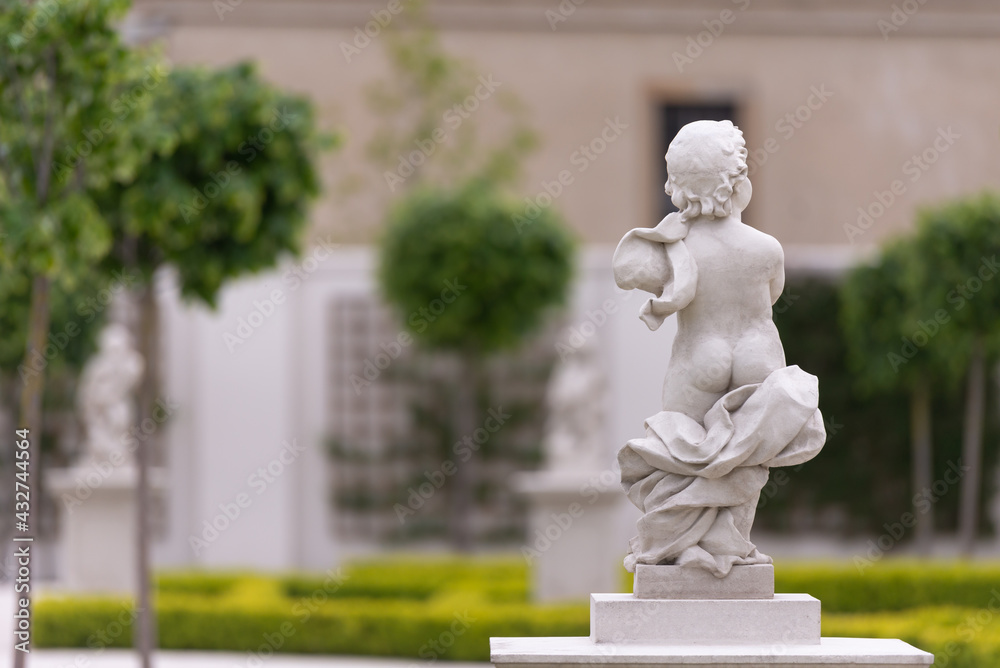 Obraz premium Bratislava Castle Park. Green bushes, young trees and statues in the garden. Statue with butt out.