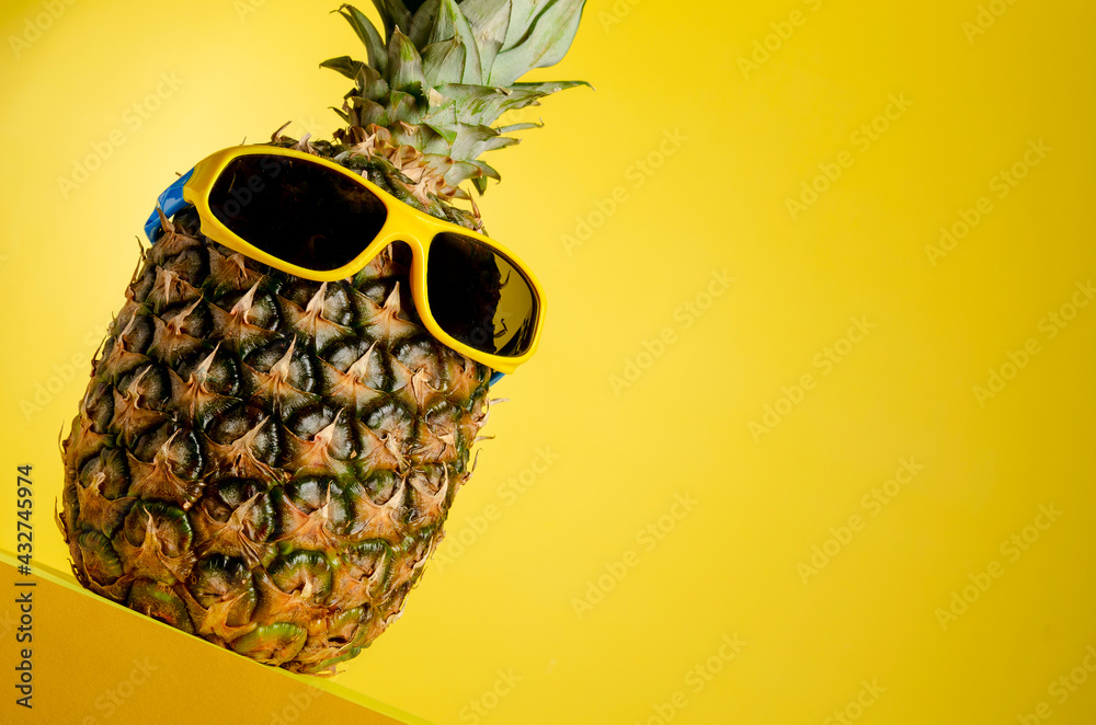 Pineapple in the sunglasses on a yellow background