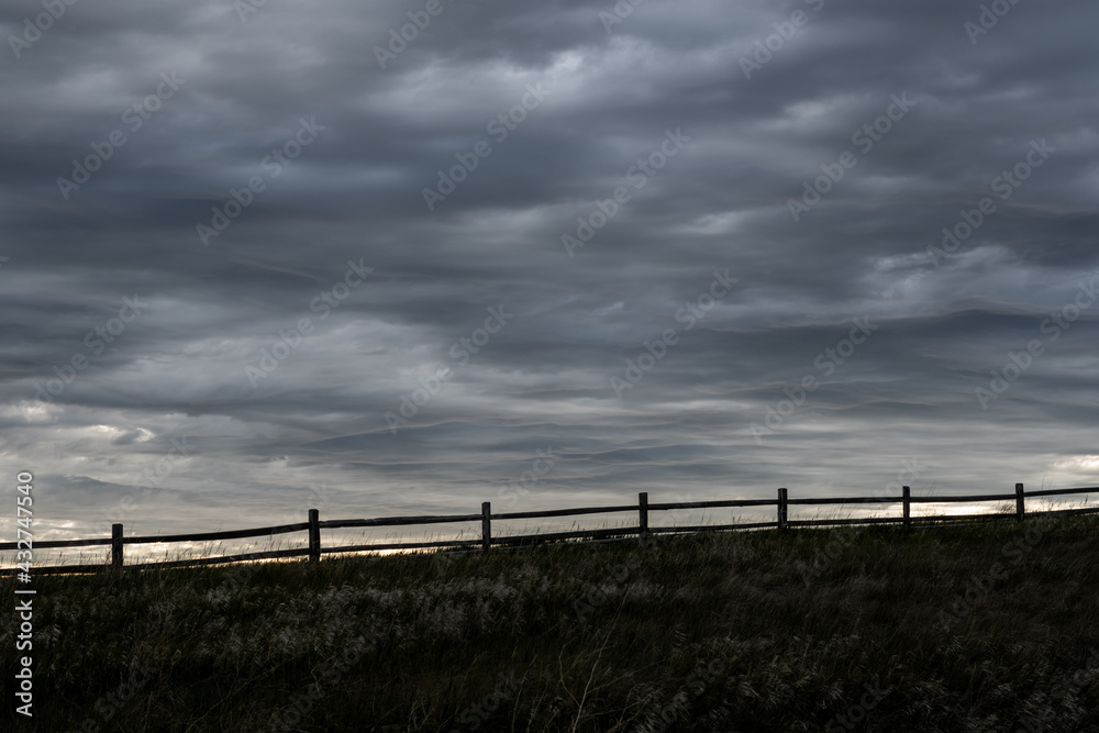Split Rail Fence Silhouette With Gray Clouds Above