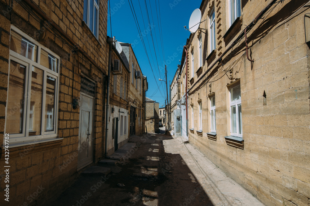 Old houses on low-rise narrow street in old part of Derbent city in Russia