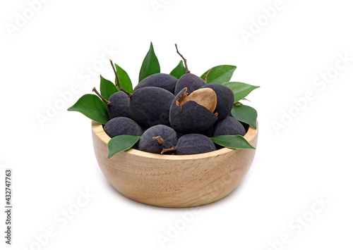 Velvet tamarind in wooden bowl isolated on white background. Black Velvet Tamarind (Dialium cochinchinense) photo