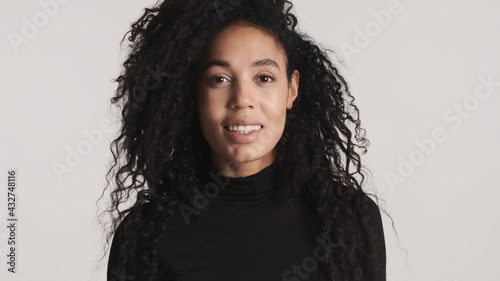 Young African American woman with dark fluffy hair dressed in bl