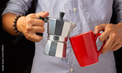 The right hand holds the coffee pot and the other hand holds the red coffee cup.