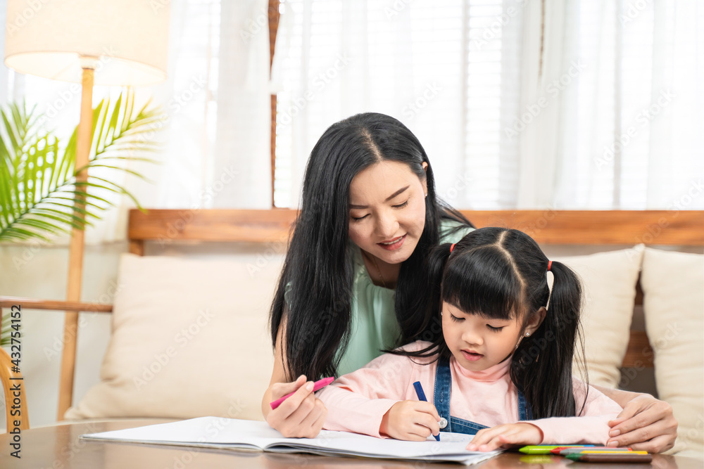 Asian girl drawing and painting picture with mother in the living room Asian girl drawing and painting picture with mother in the living room