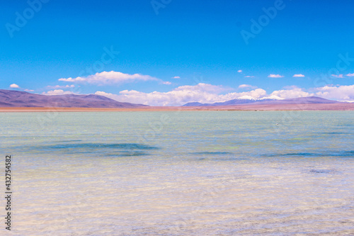 Blue lake and the mountains with snow on top at Salar de Chalviri  Bol  via 