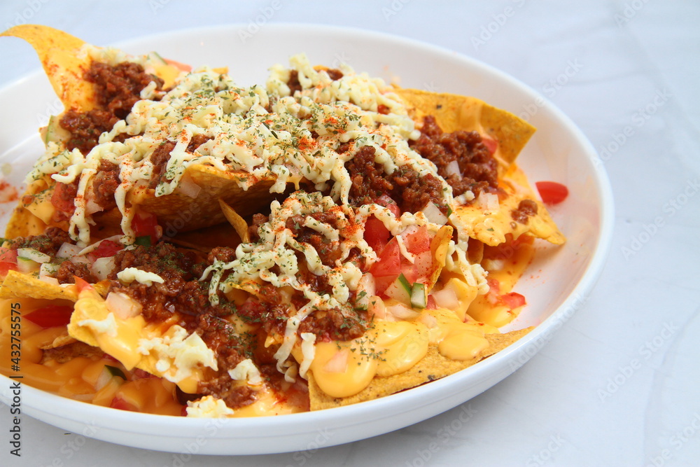 Freshly made nachos with ground beef and cheese Freshly made nachos with ground beef and cheese
