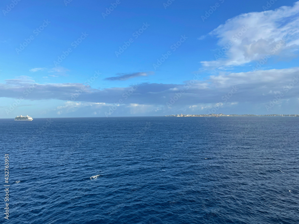 Blue sea or ocean water surface with sunny and cloudy sky
