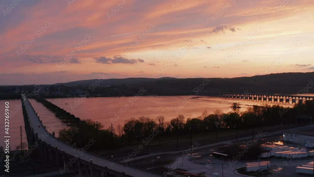 Aerial of bridges, highways over river at sunset. Beautiful sky. Government spending to repair roads and crumbling infrastructure. Aerial of bridges, highways over river at sunset. Beautiful sky. Government spending to repair roads and crumbling infrastructure.