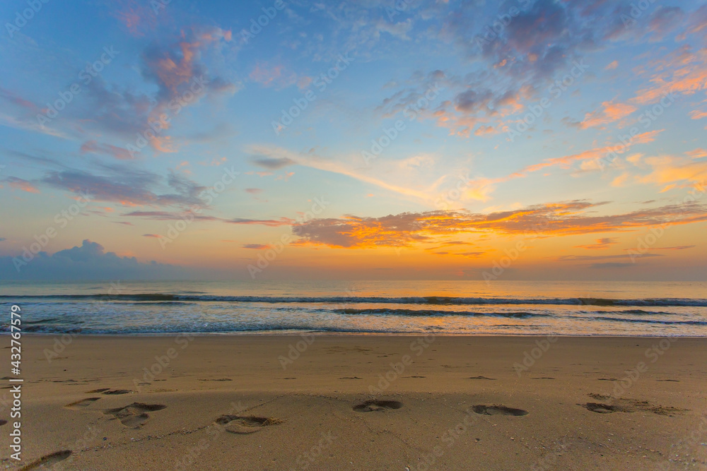 The footprints were showed on the sand in sea and sunset view with blue sky and twilight light.