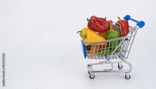 miniature grocery cart filled with colorful peppers. supermarket basket with paprika. concept of selling products and changing the price of vegetables. Sweet pepper Mini Bell.