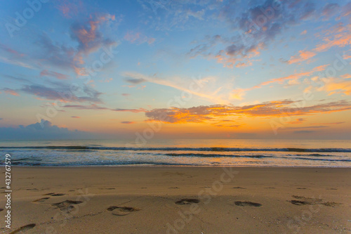 Fototapeta Naklejka Na Ścianę i Meble -  The footprints were showed on the sand in sea and sunset view with blue sky and twilight light.