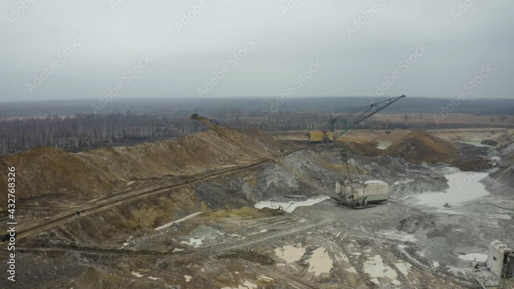Aerial view of quarry with equipment. Quarry mine industry rock extraction heavy machinery equipment. Dragline Excavator Loads Soil, Clay. Dragline excavator in surface mine area with landscape. Aerial view of quarry with equipment. Quarry mine industry rock extraction heavy machinery equipment. Dragline Excavator Loads Soil, Clay. Dragline excavator in surface mine area with landscape.