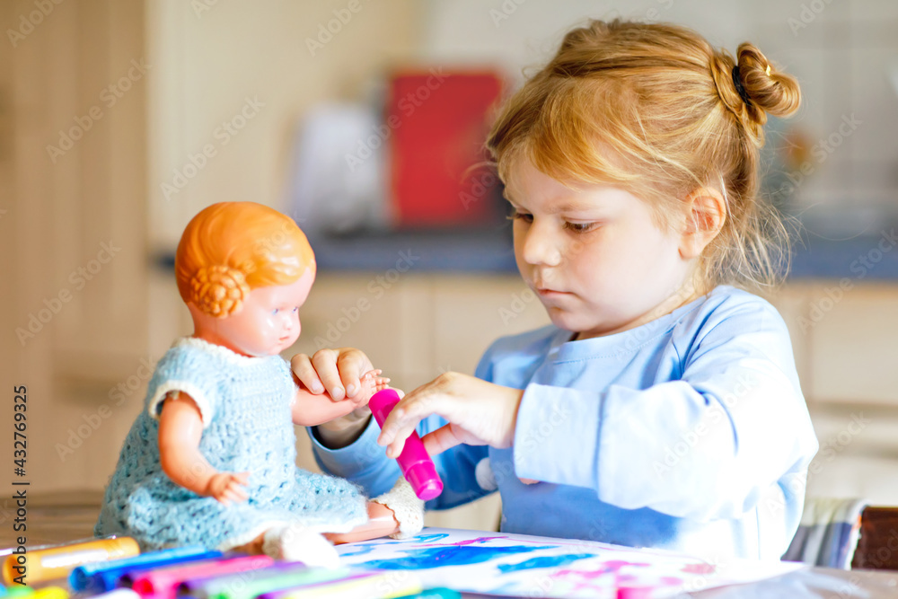 little alone toddler girl painting with felt pens during pandemic coronavirus quarantine disease. Happy creative child with old vintage doll, homeschooling and home daycare with parents little alone toddler girl painting with felt pens during pandemic coronavirus quarantine disease. Happy creative child with old vintage doll, homeschooling and home daycare with parents
