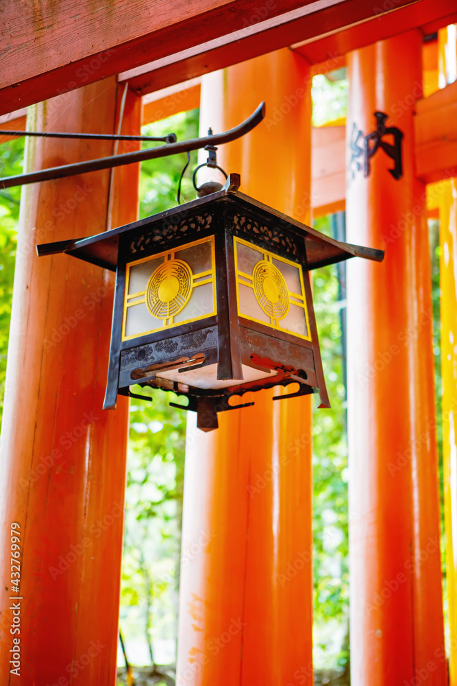 Fushimi Inari Taisha Shrine in Kyoto, Japan with beautiful red gate and japanese garden. Part of Red Torii gates in Fushimi Inari shrine in Kyoto, Japan with details. Lantern.