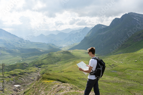 young man reading a map on a trail in the swiss alps