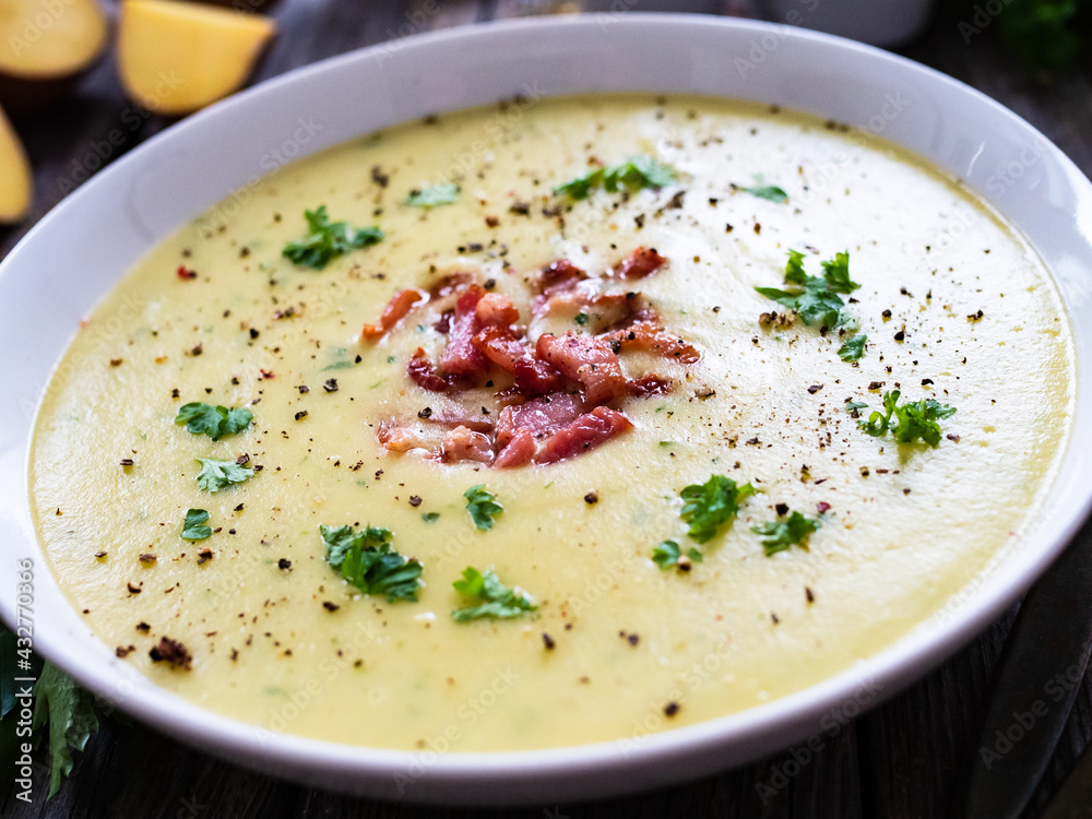 Cream potato soup with bacon on wooden table
