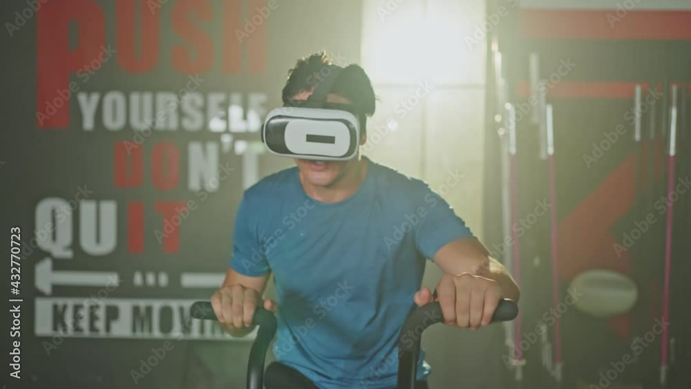 Caucasian athlete wearing VR headset, exercising by assault air bike. Caucasian athlete wearing VR headset, exercising by assault air bike.