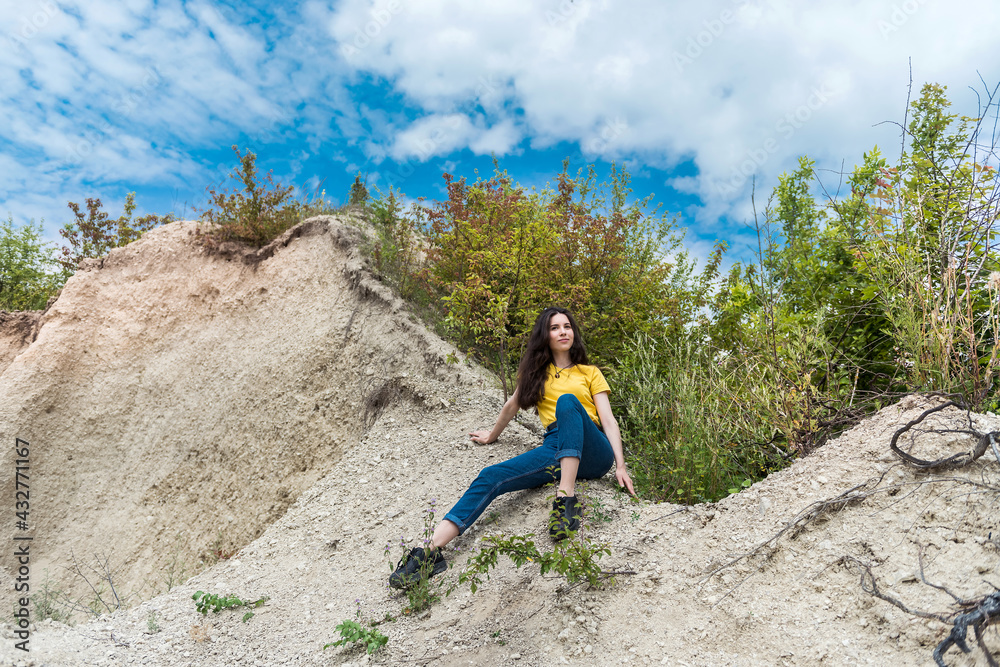 portrait of pretty slim woman standing in front of sand quarry