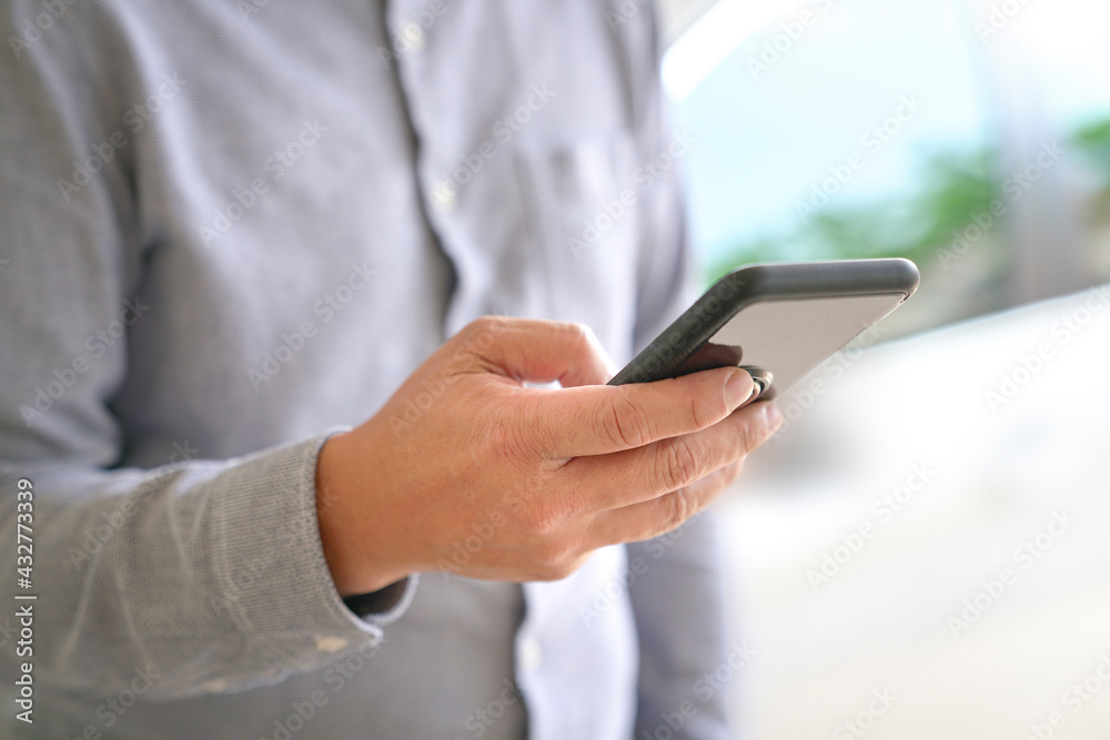 Close up view of businessman browsing or texting using his mobile phone.. Copy space. Close up view of businessman browsing or texting using his mobile phone.. Copy space.
