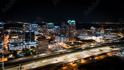 Aerial cityscape of downtown Orlando at night with the 408 expressway in the foreground.