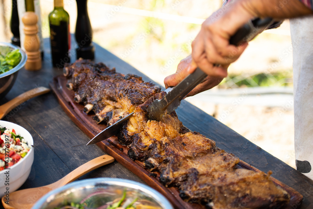 man cutting roast beef on a table