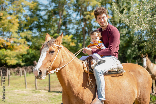 man riding horse with his daughter
