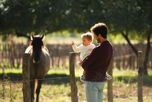 father showing horses to his little daughter