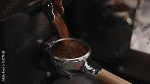 Fotografie Closeup of grinding fresh coffee into pottomless portafilter