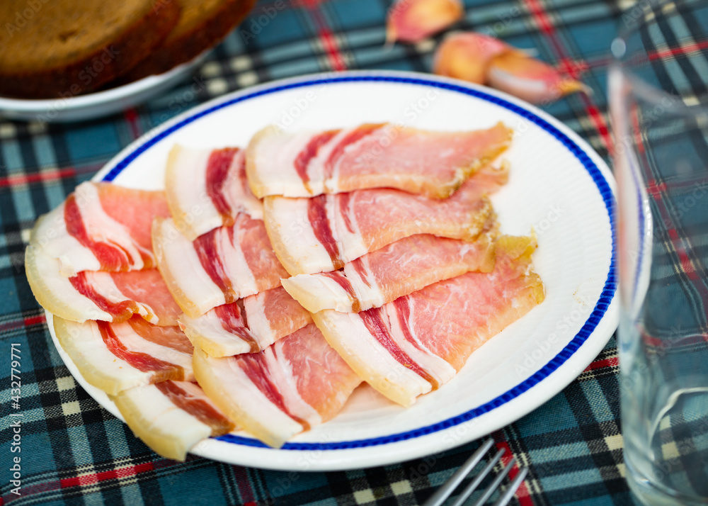 Close-up on a thin slices of fresh bacon in a restaurant