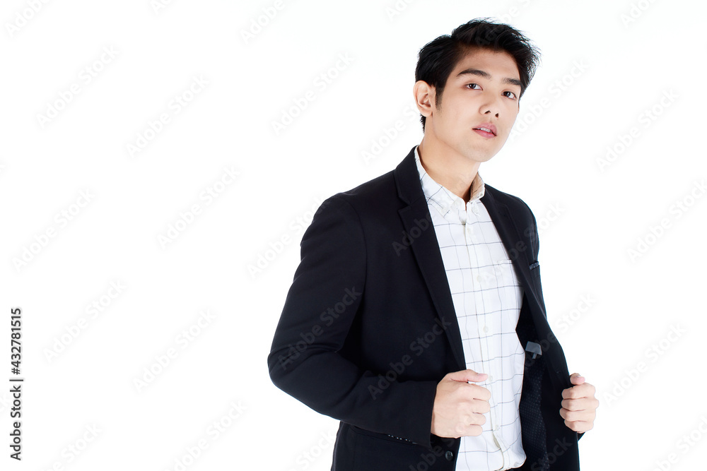 Portrait of an arrogant, confident young businessman in casual black modish suit, hand catching on his attire, looking down at a camera, standing on white background. Self-importance, egoism concept Portrait of an arrogant, confident young businessman in casual black modish suit, hand catching on his attire, looking down at a camera, standing on white background. Self-importance, egoism concept