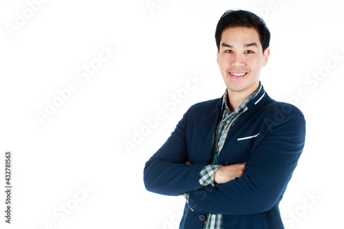 Close-up portrait of a charming young businessman in a dark blue suit , looking at the camera smiling happily with confident crossed arms, standing isolated over white background.