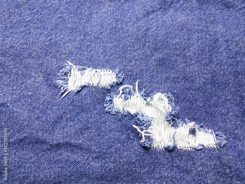 Tableau sur toile The texture of the blue jeans has a tear, visible in the white fabric inside
