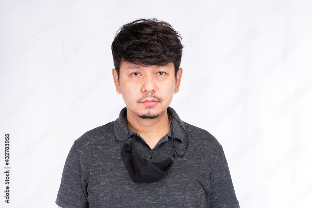 Portrait of Asian man with black face mask hanging on his neck, looking at camera isolated on white background Portrait of Asian man with black face mask hanging on his neck, looking at camera isolated on white background
