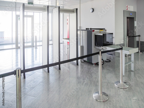 Metal detector frame and X-ray machine for checking luggage and hand baggage at entrance to public building. Checkpoint with security and anti-terrorist measures. photo