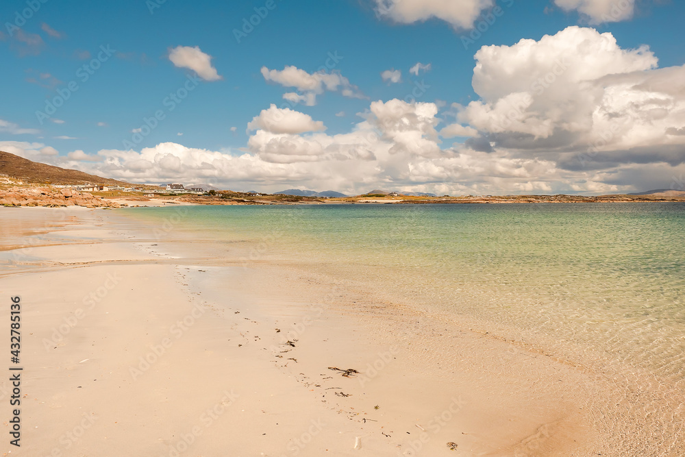 Warm sandy beach of Gurteen bay, county Galway, Ireland. Warm sunny day. Cloudy sky. Irish nature landscape.