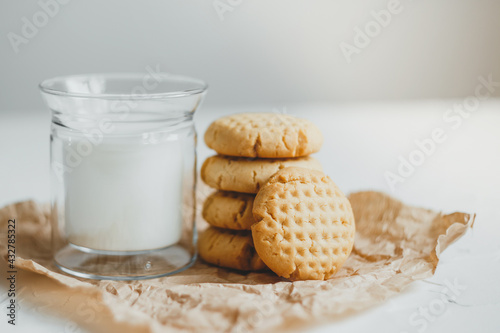 Delicious homemade peanut butter cookies with mug of milk, on white background. Healthy breakfast concept. photo